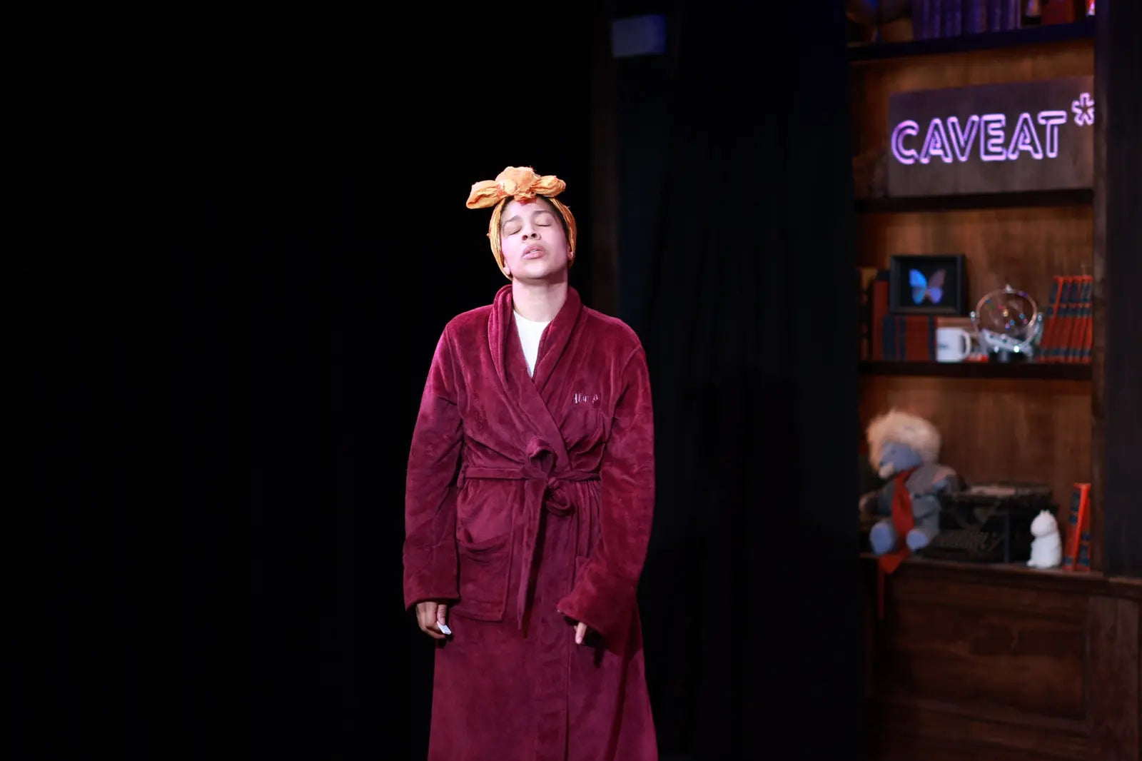 Danielle Alonzo performing in a robe during her one-woman show