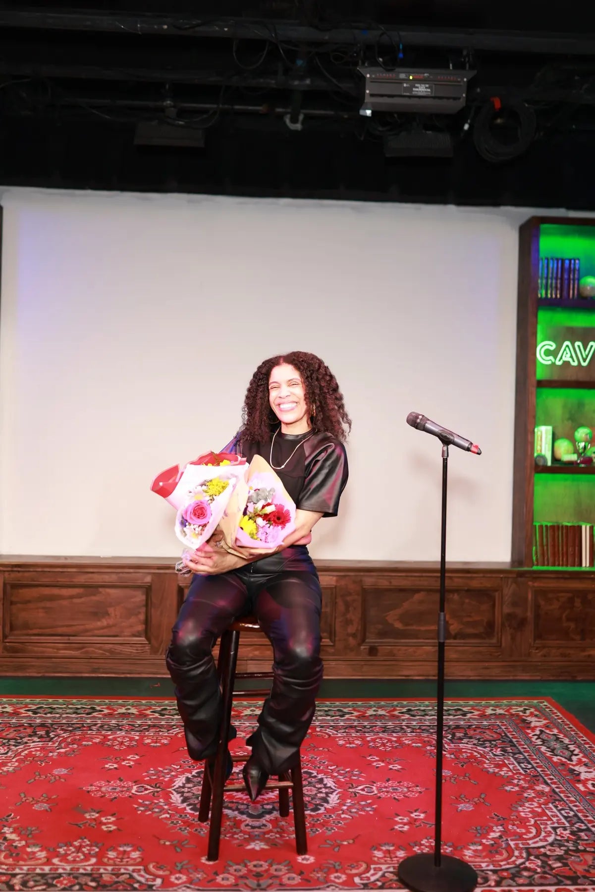 Danielle Alonzo seated on stage holding flowers